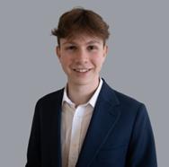 Man in black suit with white shirt and blond short hair. 