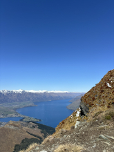 Mountain vista with view of lake and mountain range with snow on the mountain tops. 